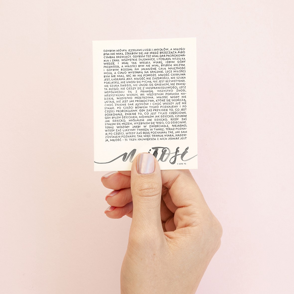 Vertical top view love romantic letter mockup Valentine with copy space for a letter. The white square card on female hand on a pink background